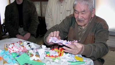 Shuzo Fujimoto at a table, with some models, in 2006 (image courtesy of Robert Lang)