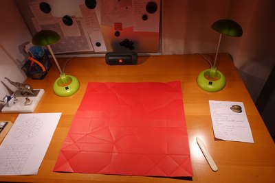 Folding a large sheet of Fabriano Colore paper into a model to be used during origami workshops