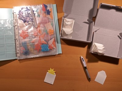 Origami models folded by Shuzo Fujimoto being moved from old to new, acid-free packaging in an effort to preserve them in good condition for many years
