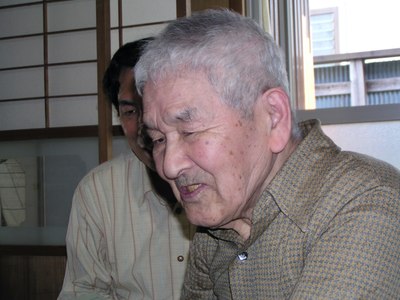Shuzo Fujimoto, portrait in three-quarter profile, Koichi Tateishi in the background. Picture by Robert Lang, taken on May 4th 2006.