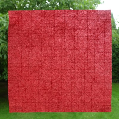 Precreased sheet of red Nicolas Terry Tissue Foil (for folding Four-Sink Base Tessellation with Larger Spacing)